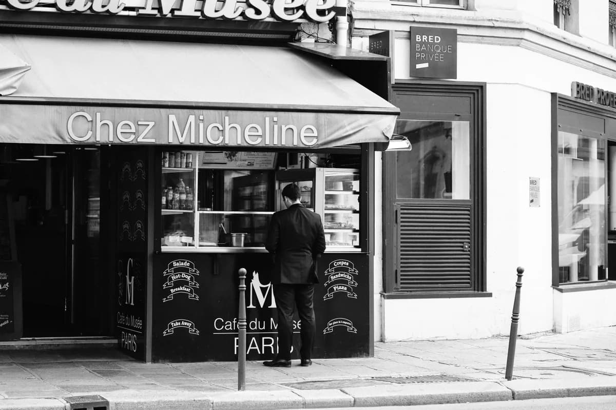 An elegant man enjoying coffee at a New Orleans café, captured in a stylish monochrome tone.