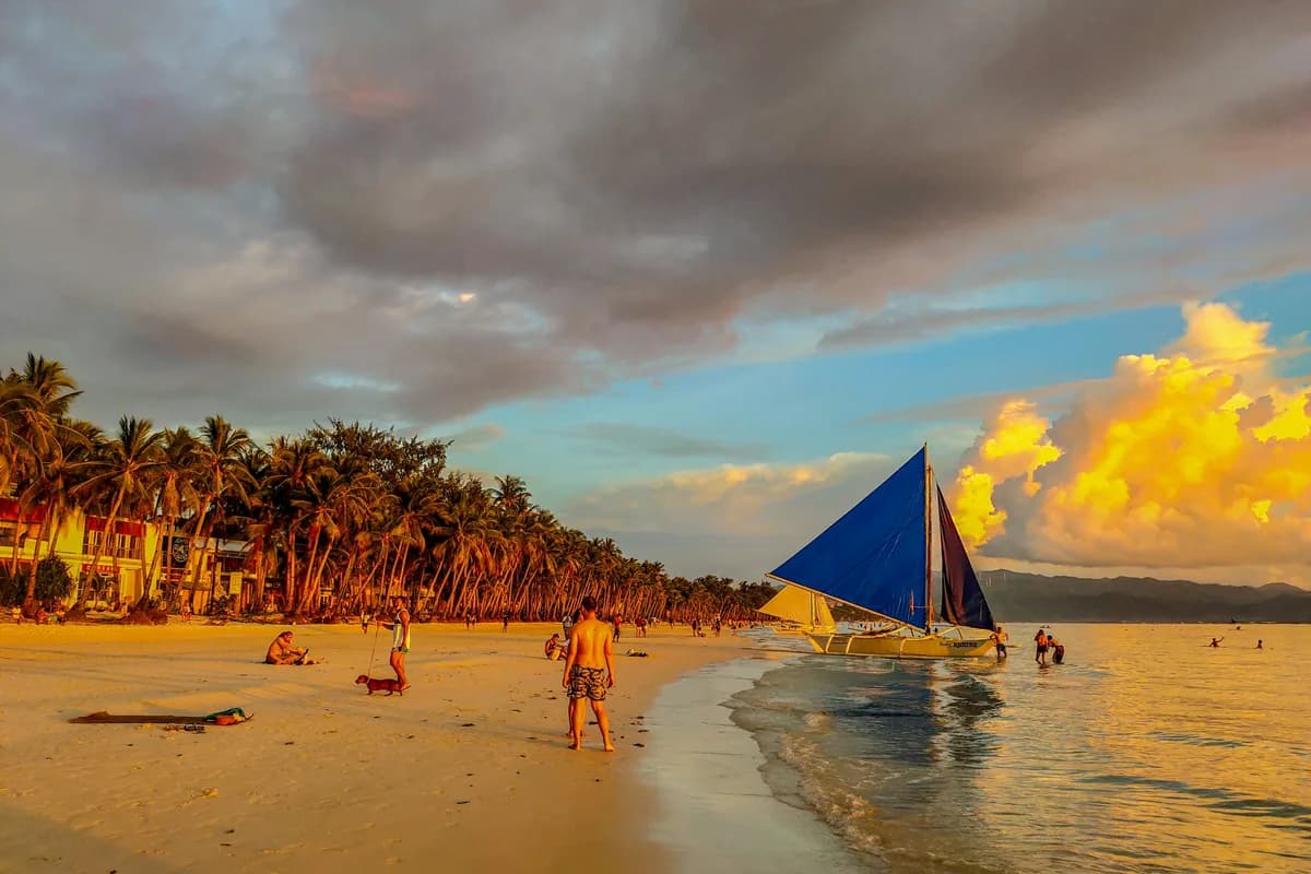 Travellers on a white-sand beach in the Philippines