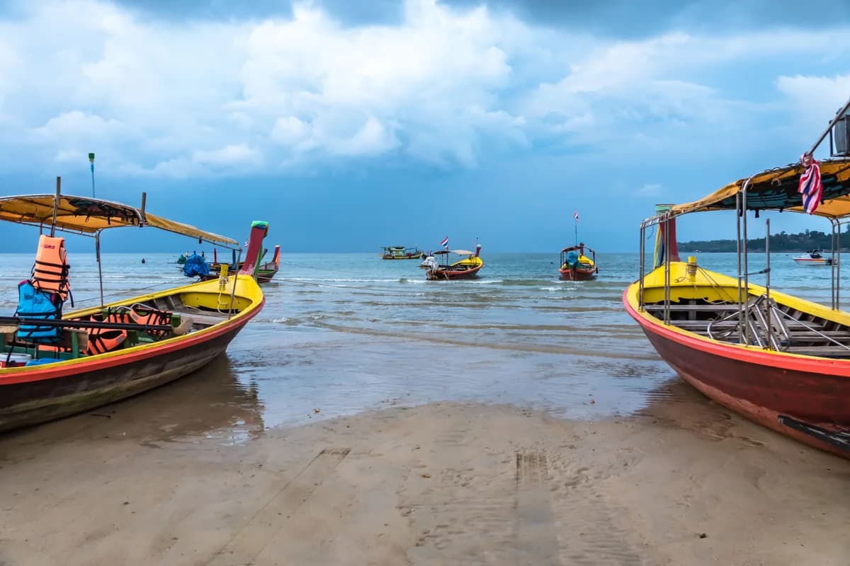 Traditional Thai long-tail boats anchored on a Phuket beach in Thailand.