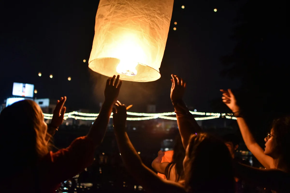 People celebrate by launching a sky lantern at night during Yi Peng festival in Chiang Mai, Thailand.