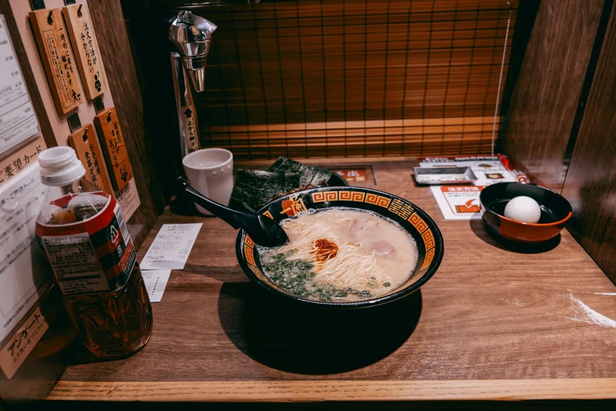 A steaming bowl of ramen served in a private dining booth at a Tokyo ramen shop.