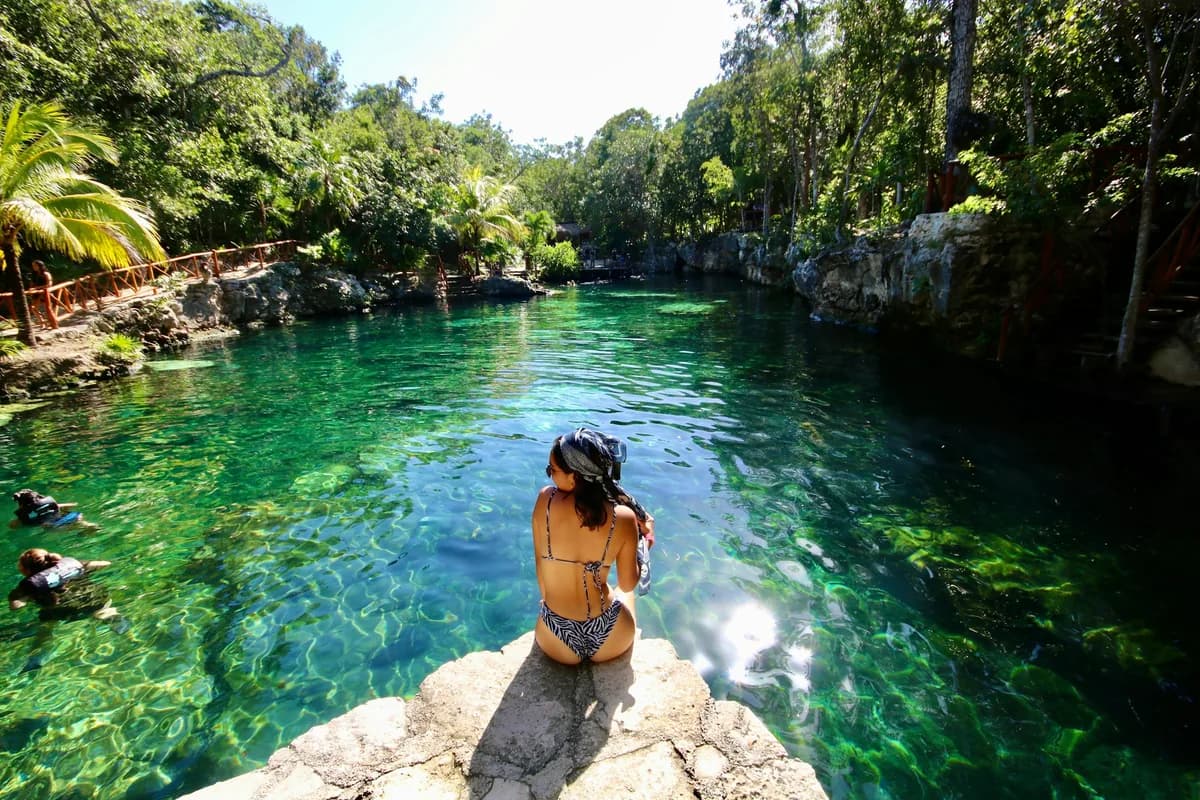 A swimmer at a turquoise cenote near Tulum