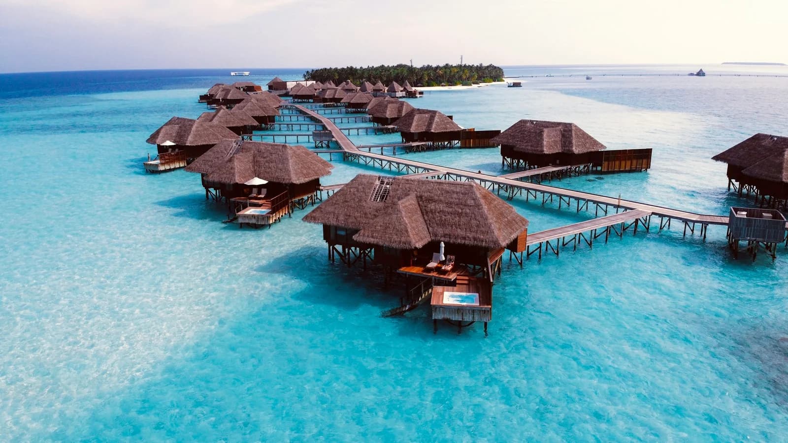 An overwater villa on stilts above the turquoise lagoon of a Maldivian atoll