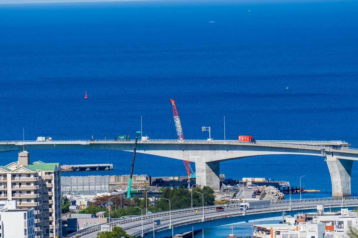 Aerial view of a coastal bridge over deep blue Okinawan waters connecting the Ryukyu islands.