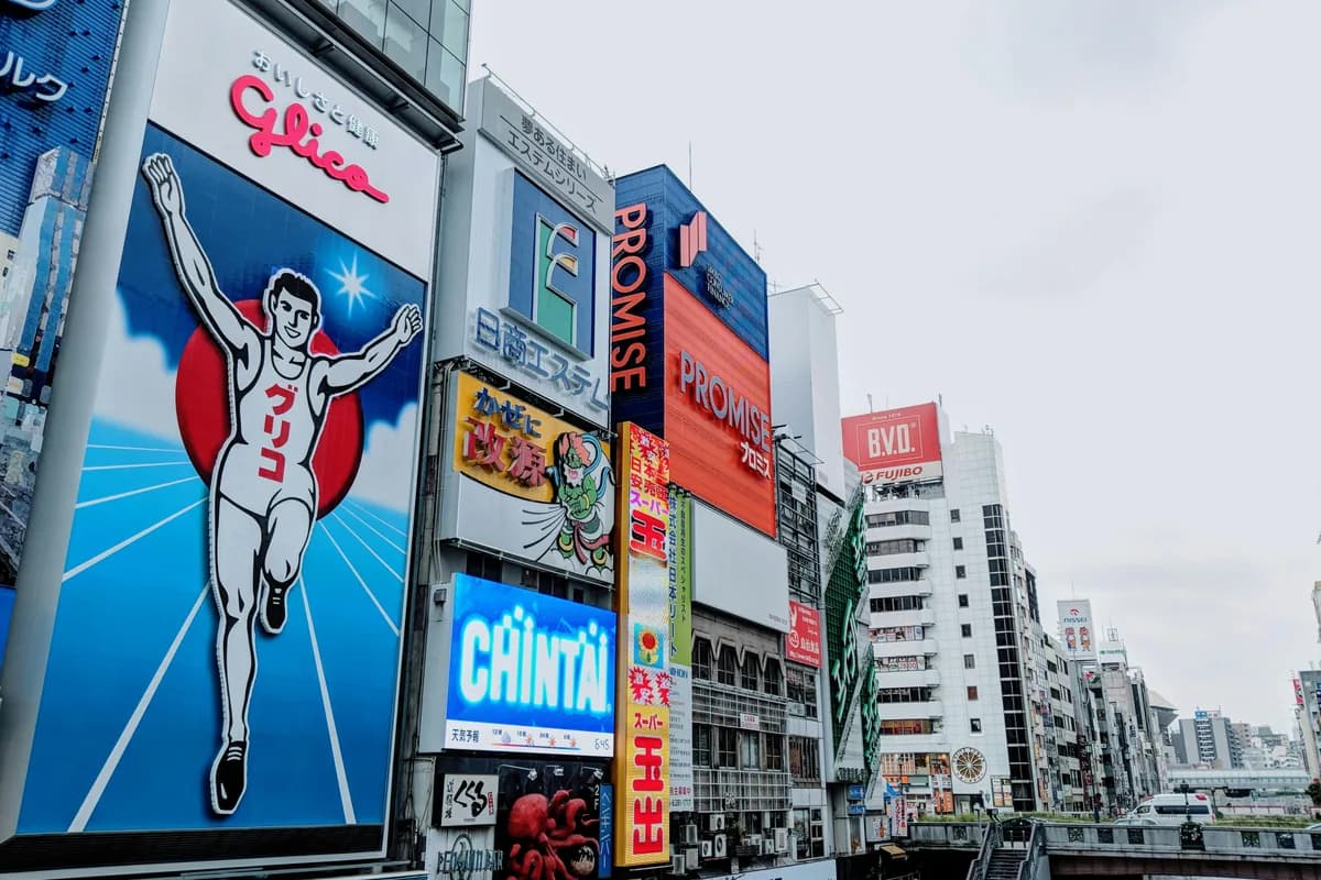 Vibrant advertisements in Dotonbori district, Osaka capturing the lively urban scene with the famous Glico Man sign.