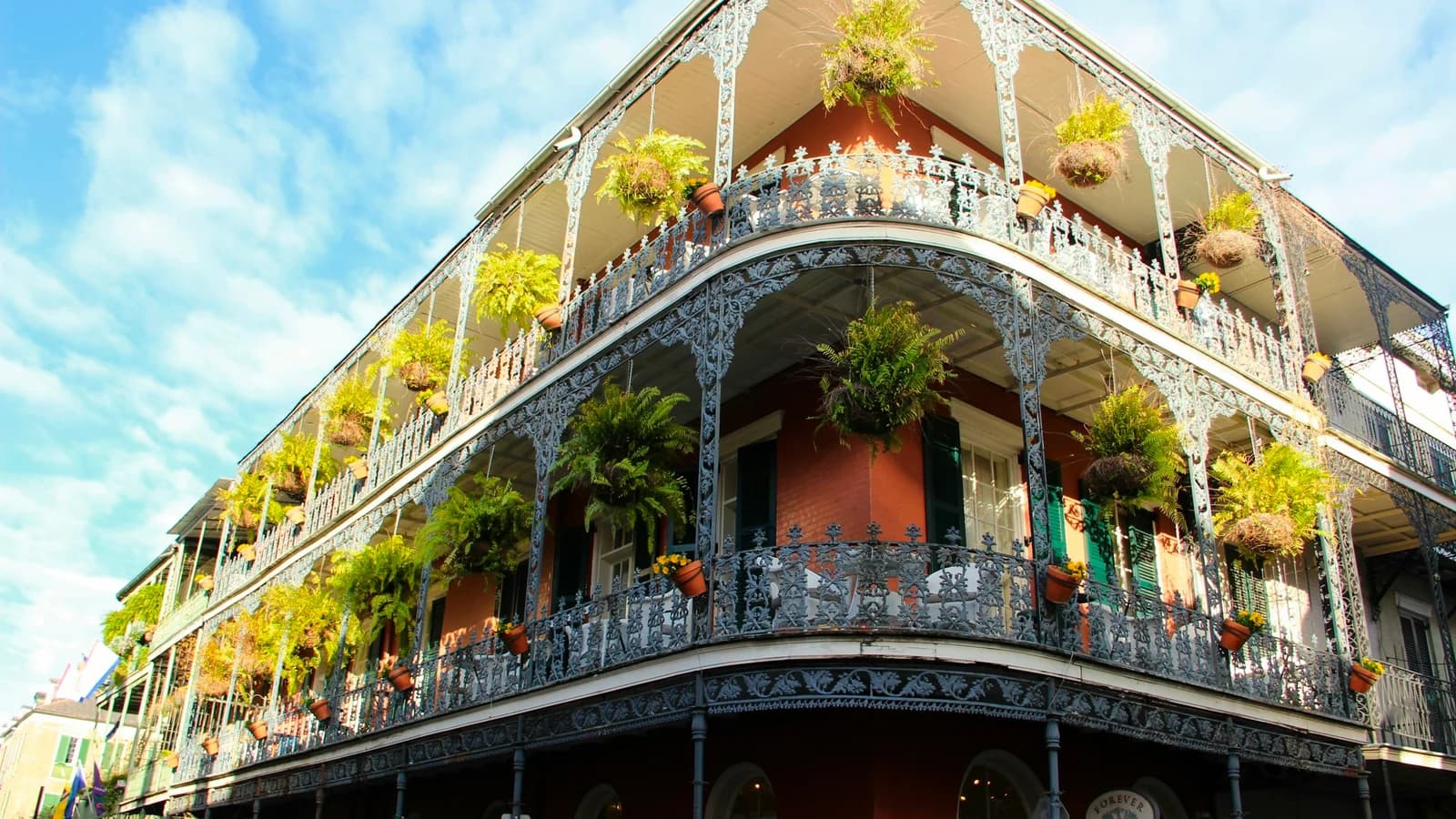 Historic French Quarter architecture in New Orleans with brown and white concrete facade under bright blue sky