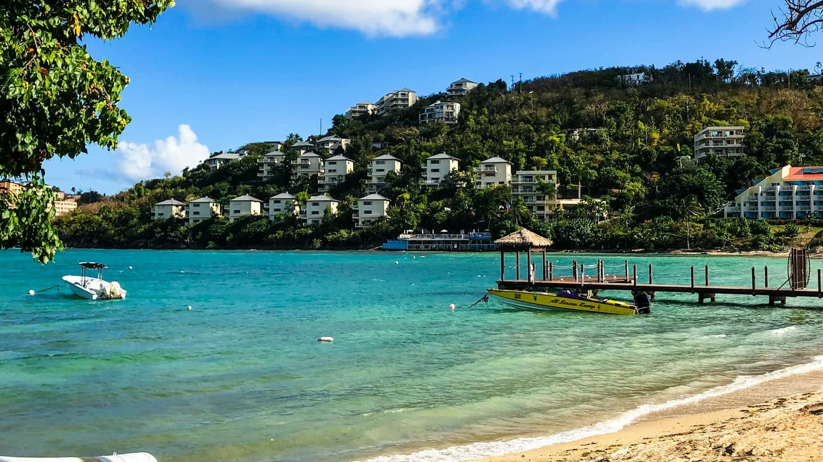 Wooden dock stretching over calm water from a beach in St. Thomas, U.S. Virgin Islands