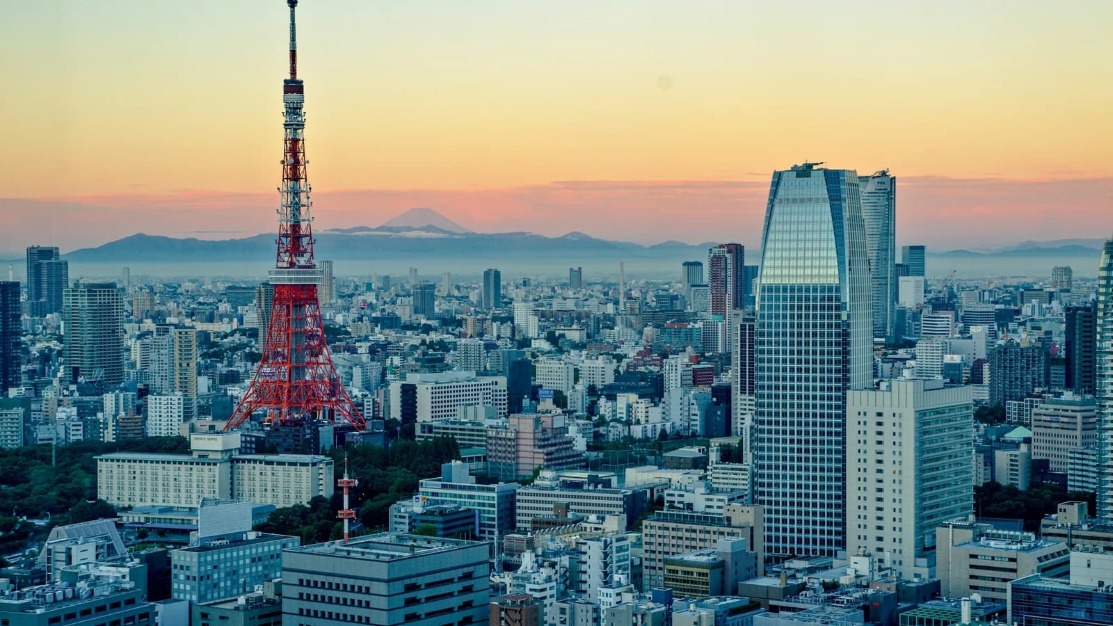 Tokyo Tower glowing red against the city skyline during the day
