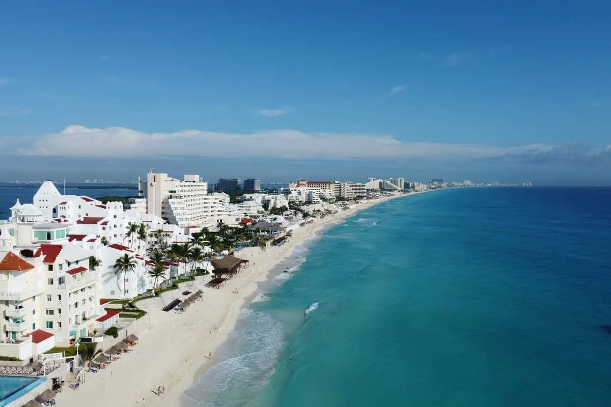 Cancun's Hotel Zone from the air: white hotels along a long beach and the turquoise Caribbean