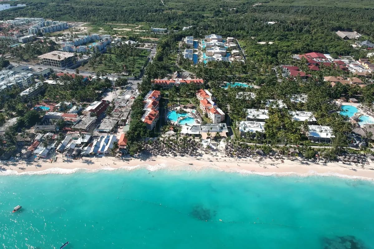 Punta Cana from the air: resorts and palm trees behind a long white beach and turquoise water