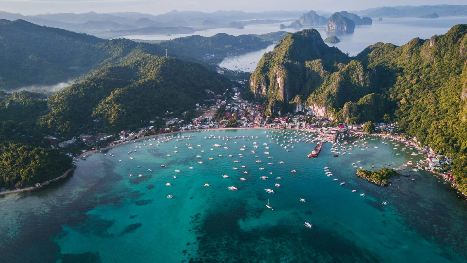 Tropical islands and outrigger boats on calm turquoise water in the Philippines